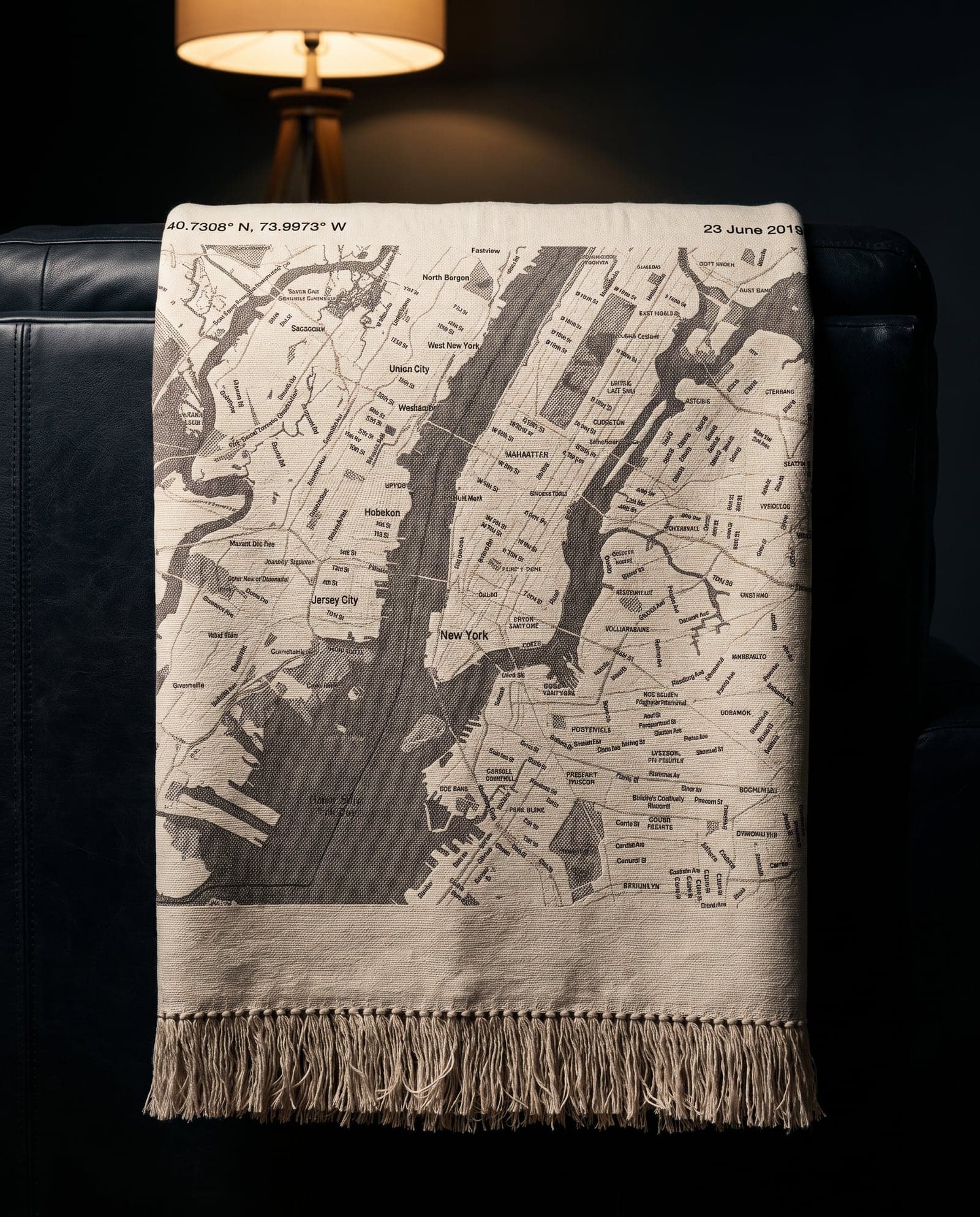 A street map woven into a fringed throw, draped over a leather armchair